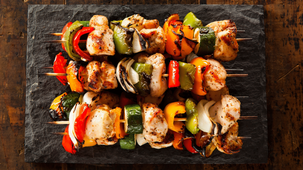 BBQ chicken kebabs with colourful grilled vegetables including capsicum, zucchini, and onion served on skewers