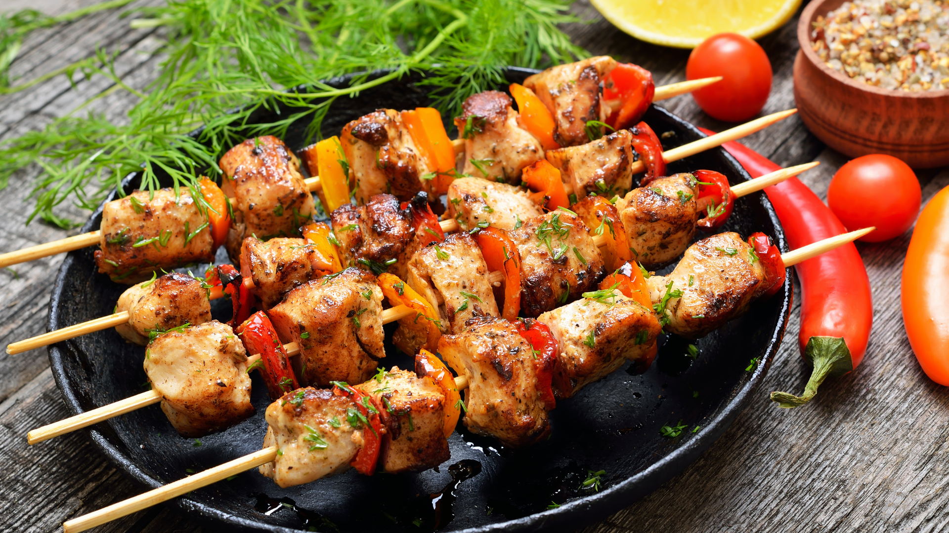 Juicy BBQ chicken kebabs with colourful vegetables grilling on a barbecue